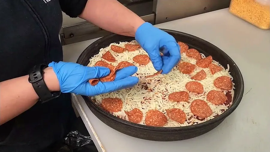 A fresh pizza being prepared at Roy's